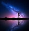 Milky Way with silhouette of a standing woman practicing yoga