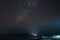 Milky Way starry sky glowing stars in the night over Gunung Api volcanic island blurred boats tropical beach Indonesia Banda