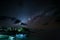Milky Way starry sky glowing stars in the night on tropical island blurred boats in the sea Indonesia Kei Islands Moluccas Maluku