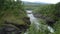 Milky white massive long waterfall down slippery valley rocks and stones in summer