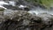 Milky white massive long waterfall down slippery valley rocks and stones in summer