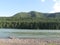 Milky white river and green forest covered mountain