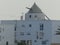 Mill above the roof of a white building in Andalusia, Spain.