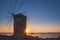 Mill on the background of the rising sun in the harbor of Mandraki. Rhodes Island. Greece