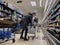 Mill Creek, WA USA - circa June 2022: View of an older woman stocking her shopping cart with gallons of water in preparation for