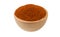 Milled or ground paprika or red pepper in wooden bowl isolated on white background. 45 degree view. Spices and food ingredients