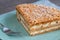 Millefoglie or mille-feuille pastry on a plate, powdered sugar