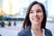 Millenial businesswoman smiling confidently with cityscape background