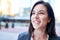 Millenial businesswoman smiling confidently with cityscape background