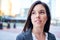 Millenial businesswoman smiling confidently with cityscape background