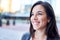 Millenial businesswoman smiling confidently with cityscape background