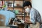 Millennial african american barista with in apron, protective mask and gloves makes take-out latte for client