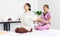 Millennial Asian professional female Thai masseuse aromatherapy therapist in uniform sitting on massaging bed holding customer