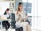 Millennial Asian young professional successful female businesswoman in formal suit high heels sitting smiling posing on chair