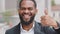 Millennial bearded black young male businessman boss showing thumb smiling demonstrates satisfaction praise. African