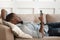 Millennial biracial man using cellphone resting on comfy sofa