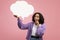 Millennial black woman holding empty speech bubble on pink studio background, mockup. News, dialog, announcement