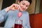 Millennial caucasian girl dyeing easter egg on red liquid