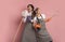 Millennial couple having fun during spring cleaning, using broom like air guitar and singing into mop