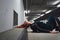 Millennial girl with head tilted back laying on floor in parking house. Female model red hairs directing to ventilation