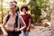 Millennial girlfriends walking together during a hike in a forest, close up