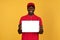 Millennial glad black man courier in red uniform show tablet with empty screen