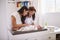 Millennial Hispanic mother and grandmother playing with baby son on changing table, selective focus