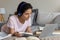 Millennial lady lie by laptop in headset listen to teacher