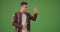 Millennial Latino man calling for taxi or ride sharing service on green screen
