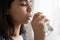 Millennial mixed race woman drinking crystal clear water.