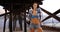 Millennial white woman stands under the pier posing for a portrait