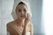 Millennial woman do facial peeling in home bathroom