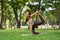 Millennial woman wearing sportswear doing yoga in Half bow pose or Ardha Dhanurasana at nature garden