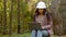 Millennial woman young experienced specialist forestry engineer environmentalist technician in hardhat checking trees