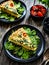 Millet quiche with spinach, black olives, cherry tomatoes and ricotta on wooden table