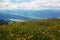 Millstaettersee - Lush and vast pasture with a lot of wildflowers on it and panoramic view on the Millstaettersee lake