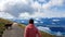 Millstaettersee - A woman in orange hoodie hiking along a gravelled road and is encountered by a small calf in Austrian Alps