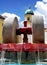 Millstone in a fountain and a city clock on a cultural monument in the background. Cultural and traditional heritage of the