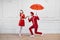 Mime artists in red costumes, scene with umbrella