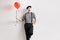 Mime holding a balloon and leaning against wall