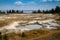 Mimulus Pool, a thermal feature in the West Thumb Geyser Basin of Yellowstone National Park. Yellowstone Lake in background