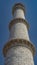 The minaret of the ancient Taj Mahal against the blue sky