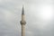 Minaret of turkish mosque in overcast sky.