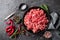 Mince. Ground meat with ingredients for cooking on black background