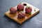 Minced beef garnished with coriander leaves on wooden board