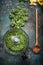 Minced chopped kale leaves on rustic background with wooden cooking spoon and chopper