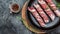 Minced meat wrapped in bacon on cast iron plate. chevapchichi or Kofta kebab. raw sausages of ground beef or pork with onions and