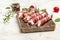 Minced meat wrapped in bacon on cast iron plate. chevapchichi or Kofta kebab. raw sausages of ground beef or pork with onions and