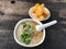 Minced pork congee with deep fried garlic and vegetable in white bowl. Serve with deep fried dough stick.