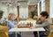Mind sport. Side view of two smart little boys playing chess while sitting at the table in school